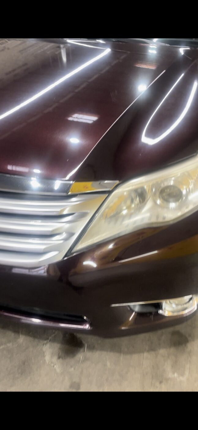 Paint enhancement — shop lights mirrored in a polished deep-maroon hood
