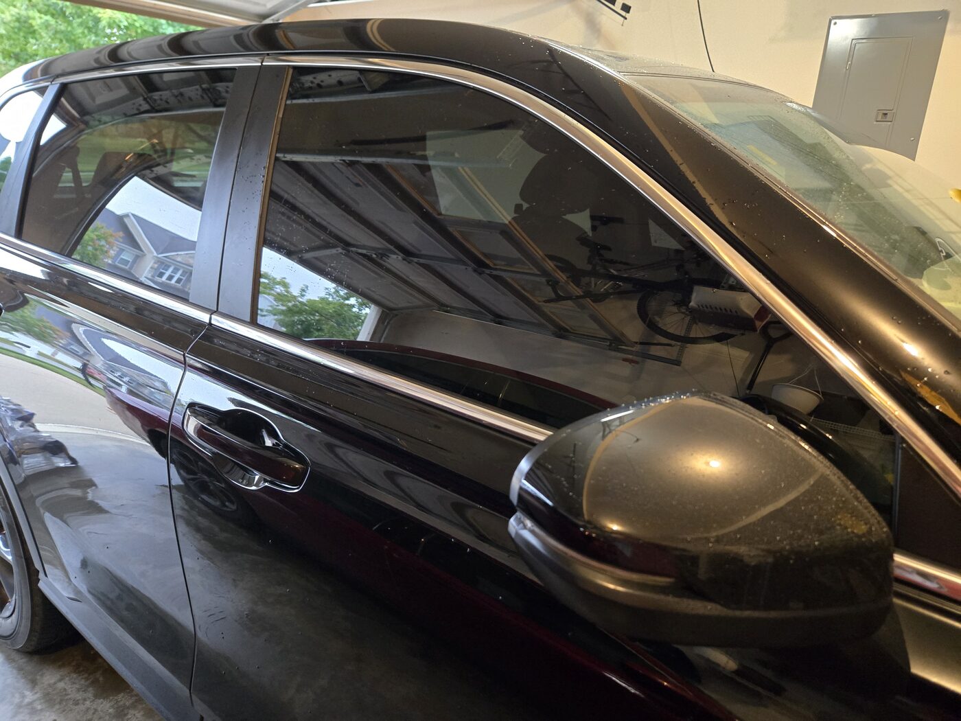 Fresh window tint and gleaming chrome trim on a detailed black sedan