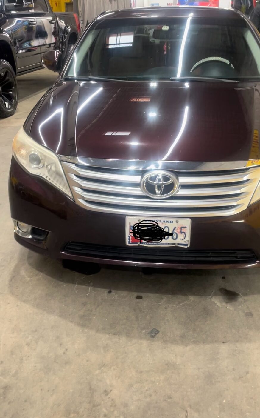 Deep-maroon sedan with a showroom-level gloss, fresh on the shop floor